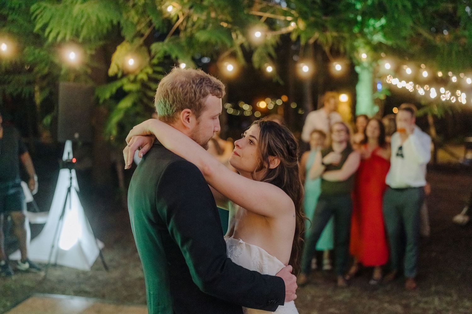 Evening wedding celebration with string lights and dancing under the stars.