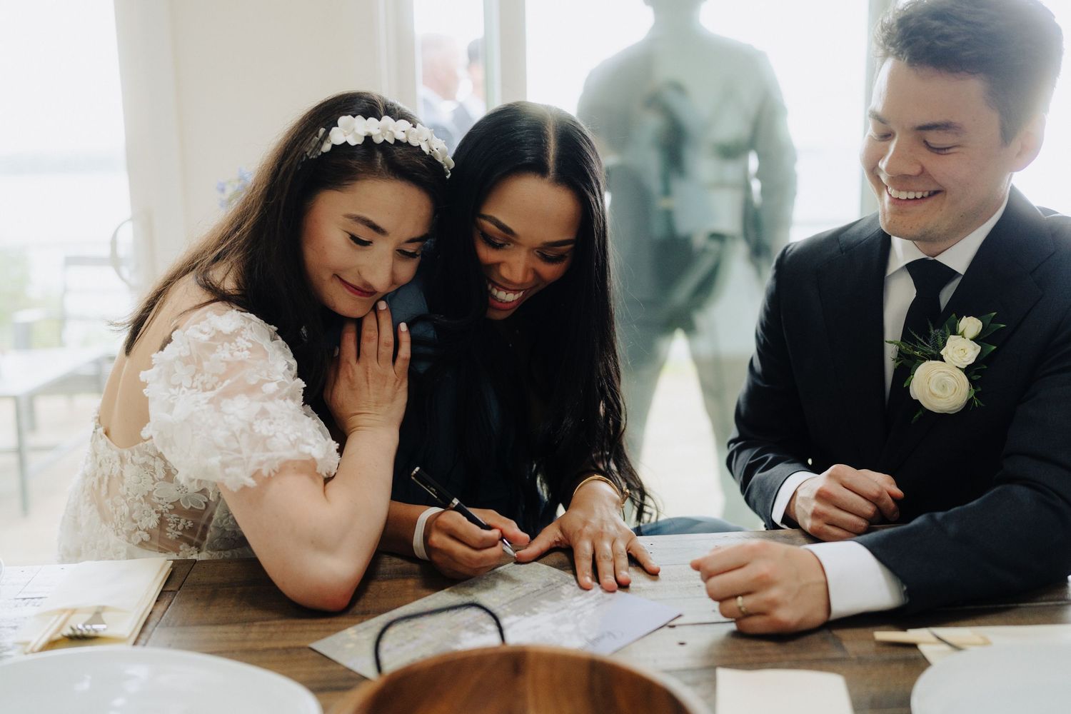 Wedding party members sharing casual moments and looking at phones together.