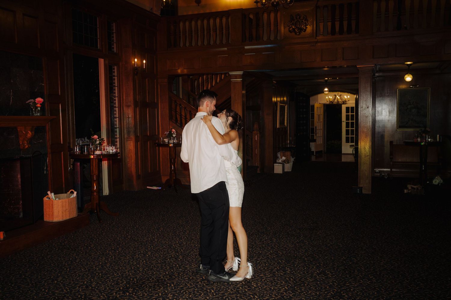 Couples dancing in a dark indoor venue during evening reception.