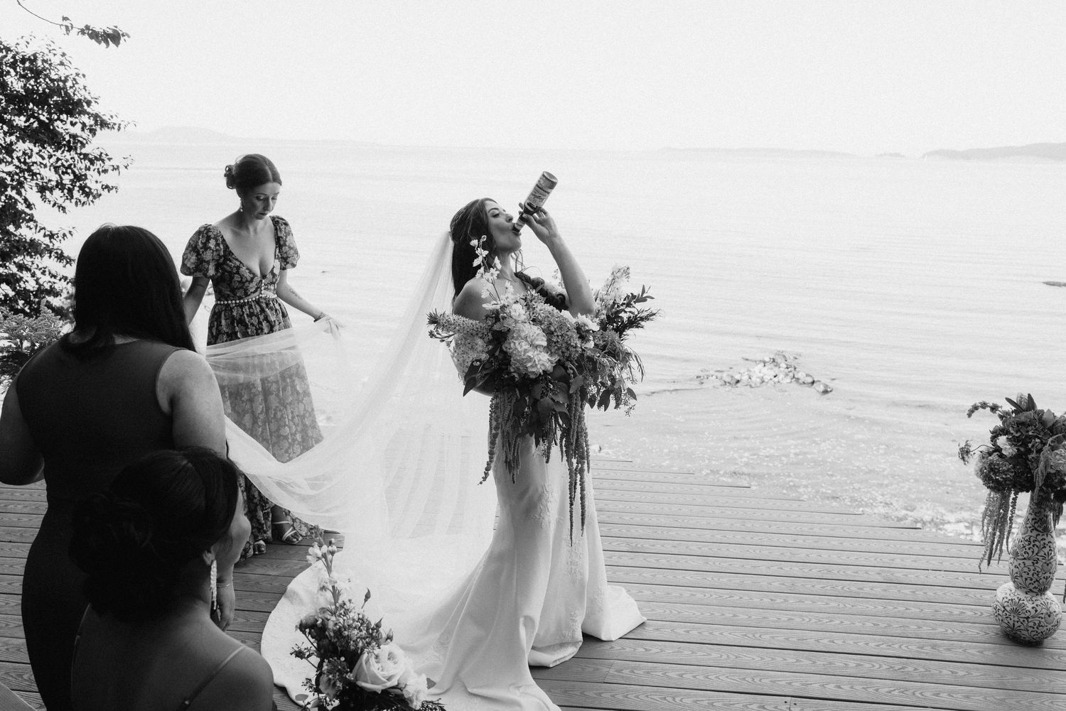 Black and white wedding photography captures candid moments on an outdoor deck.