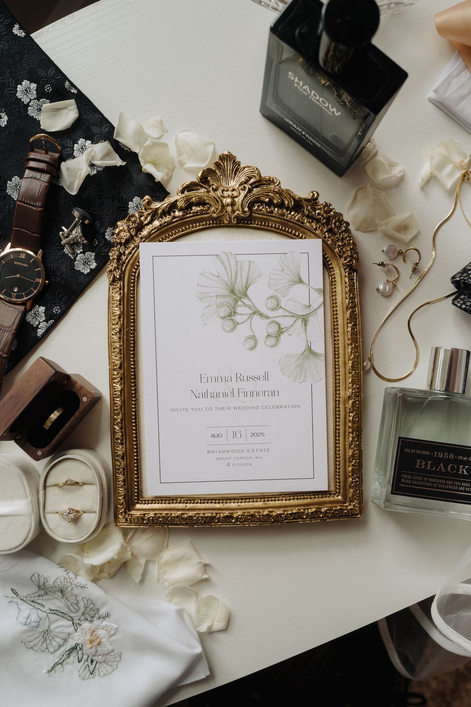 Elegant wedding invitation displayed in an ornate gold vintage frame with delicate floral details.