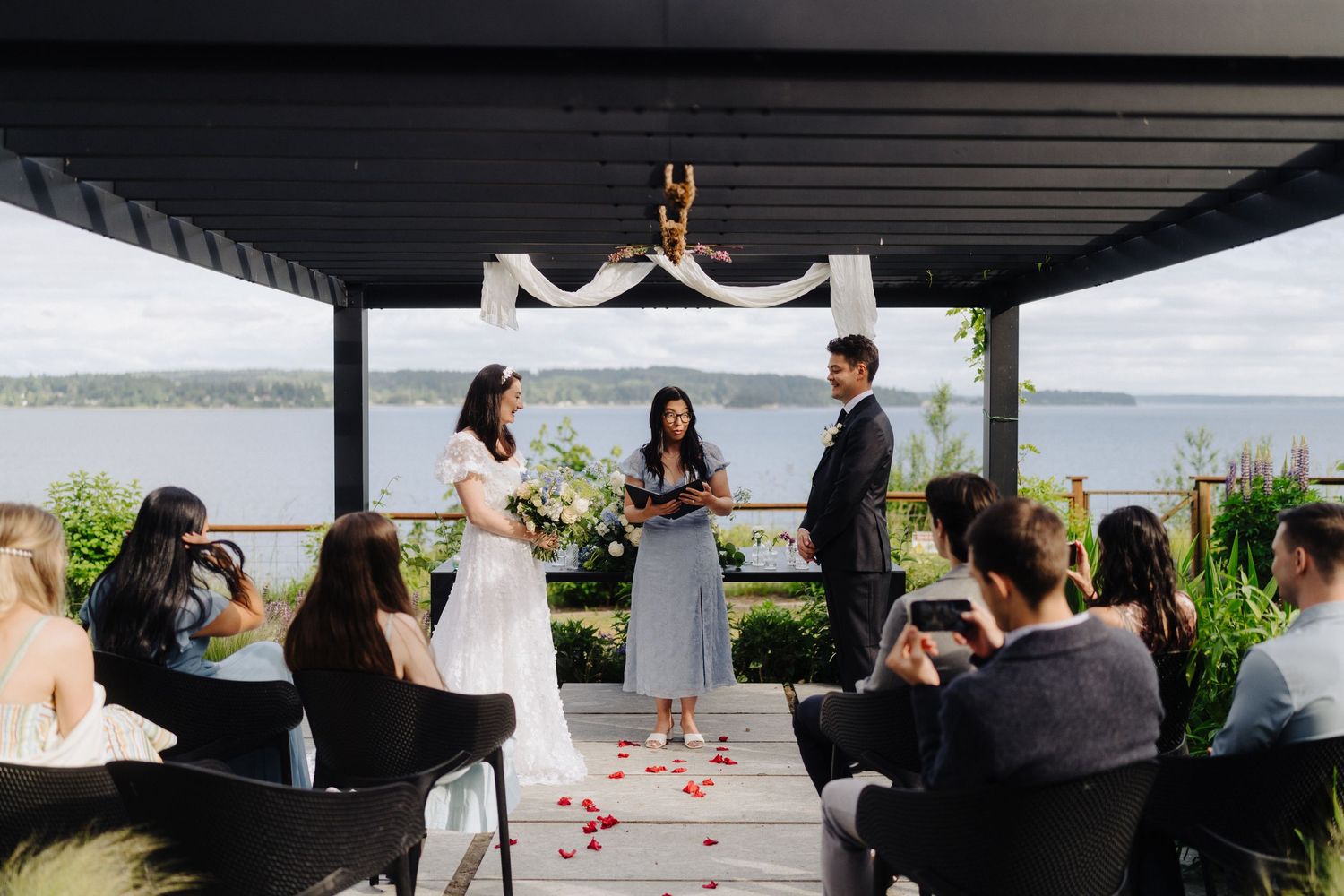 Covered outdoor wedding ceremony space overlooking a waterfront view.