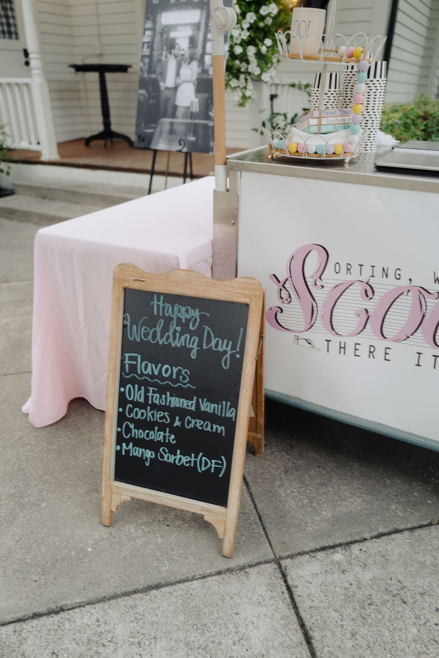 Wedding reception chalkboard signs display menu items and messages on wooden easels with pink decor.
