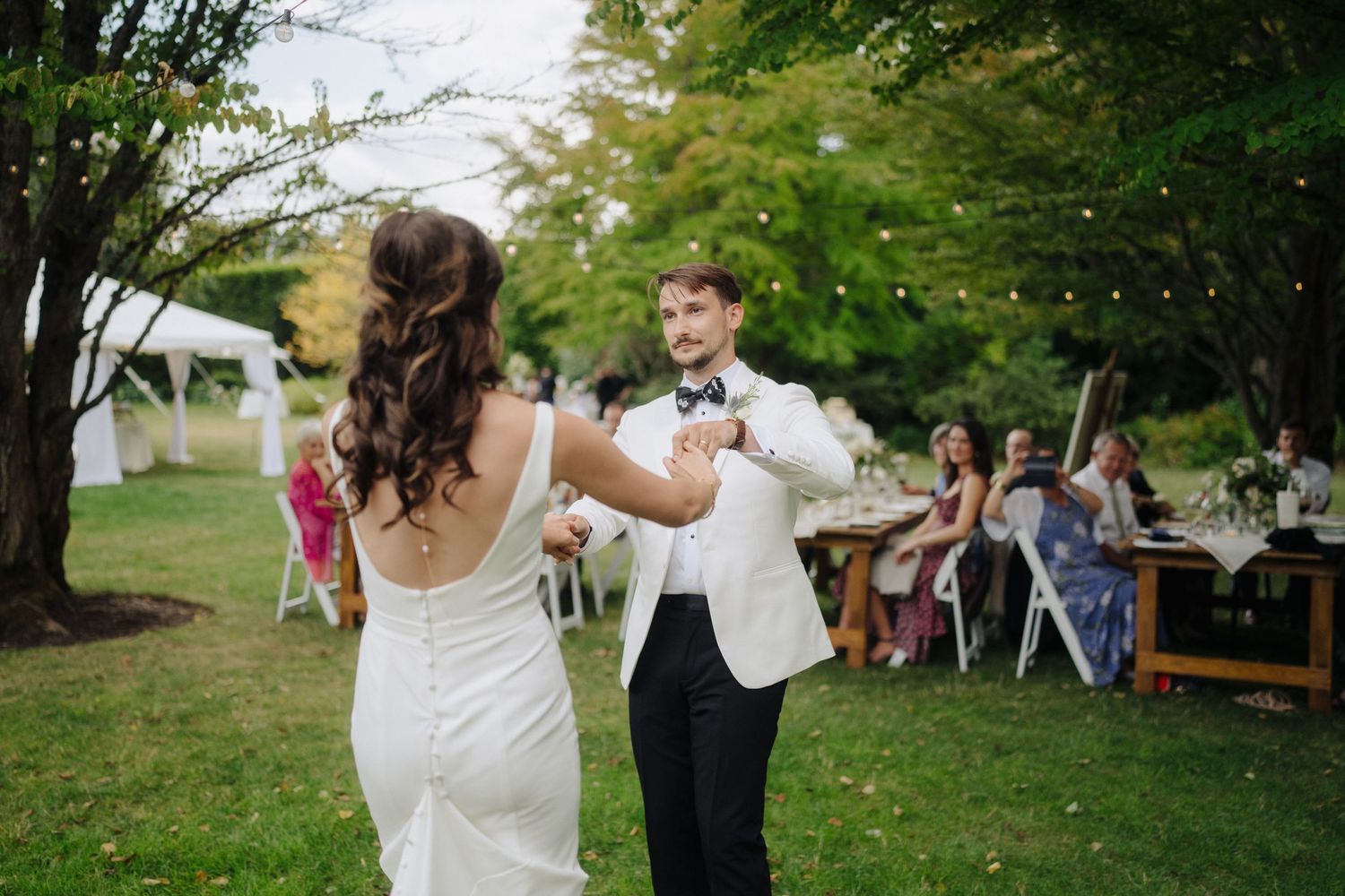Wedding celebration in an outdoor garden setting with guests mingling.