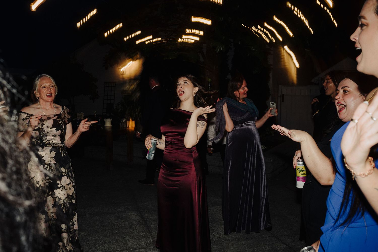 Group dancing and celebrating in dark venue with dramatic lighting.