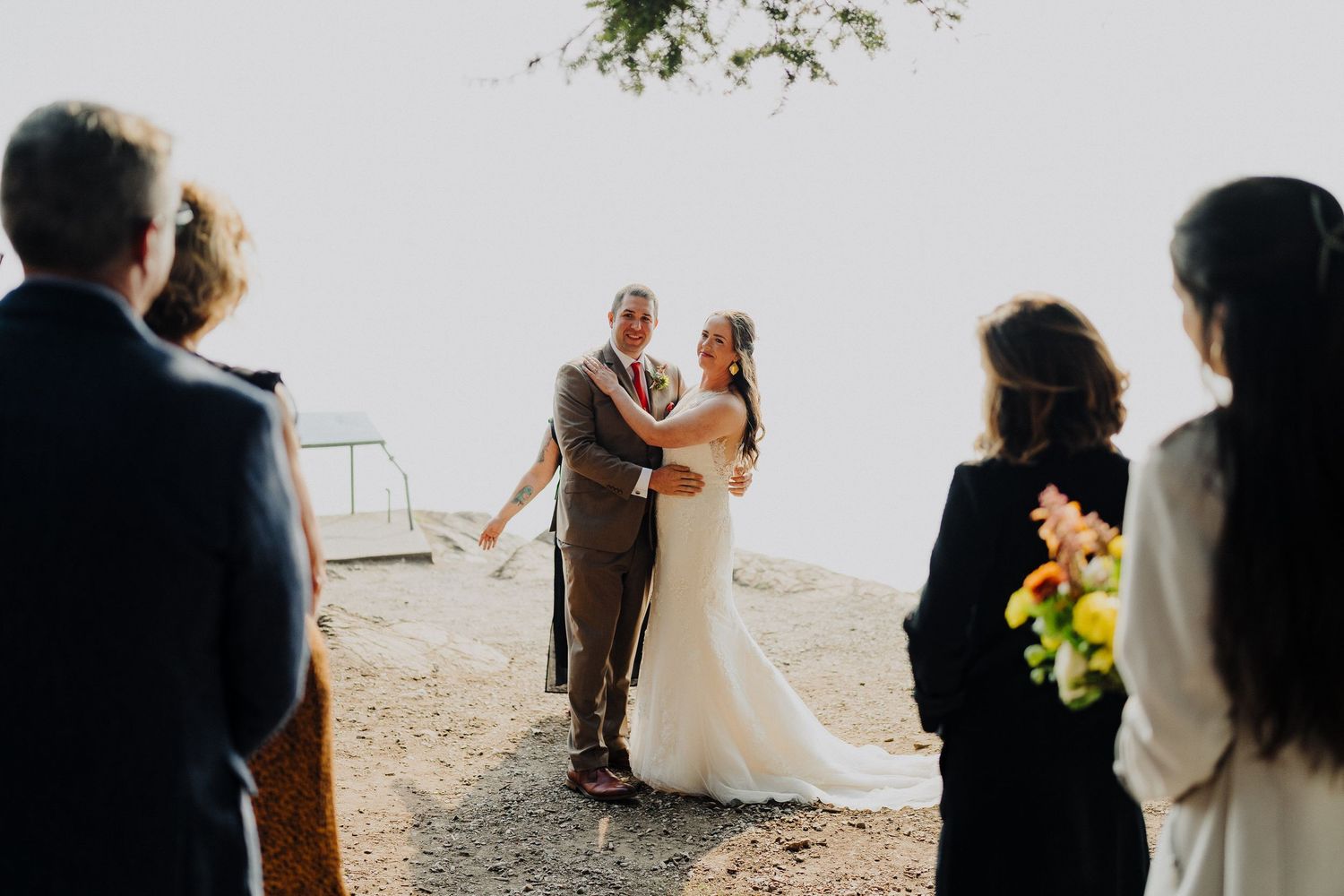 A couple shares their first dance at a scenic outdoor mountain wedding ceremony overlooking a valley.