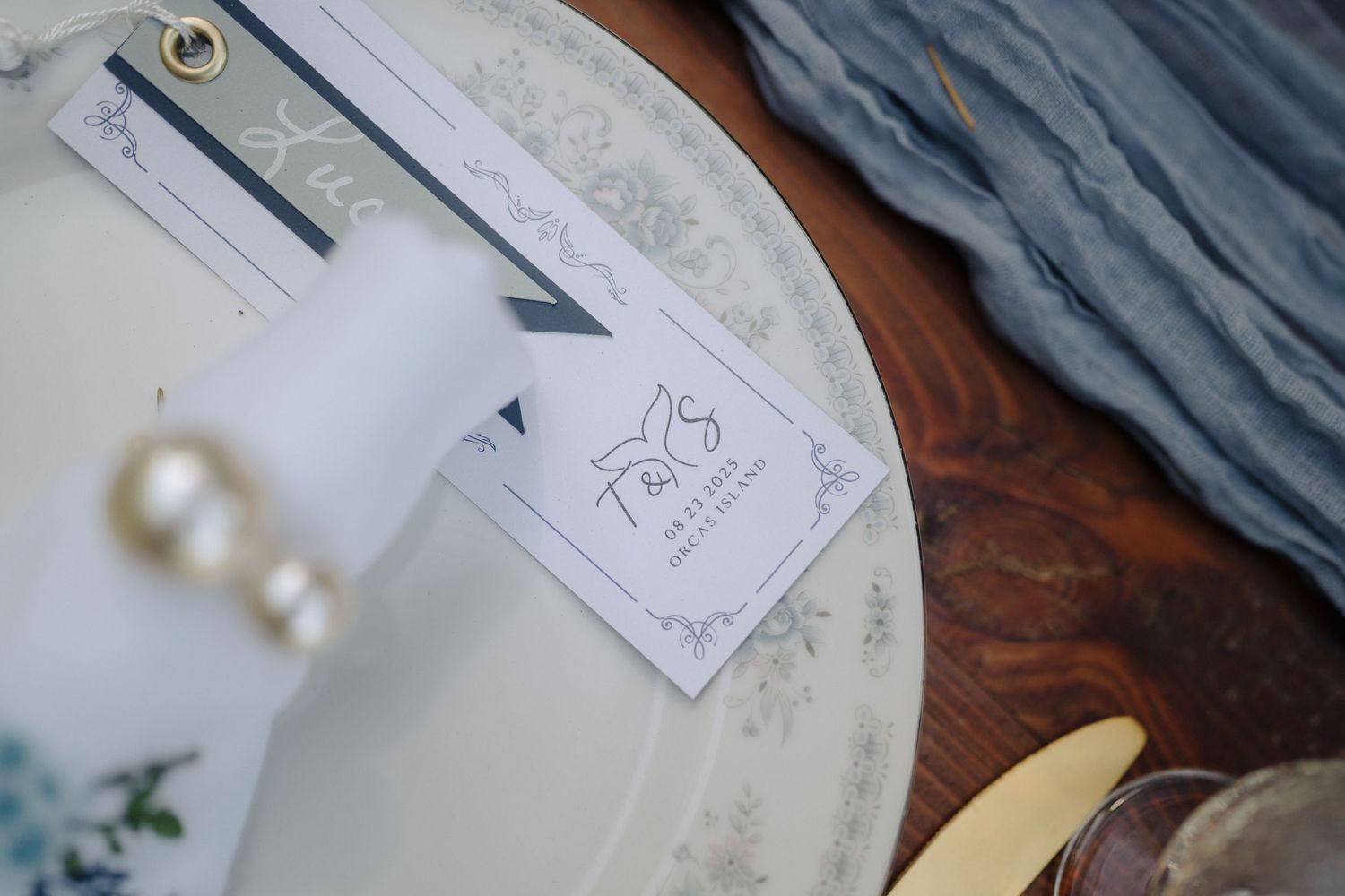 Wedding stationery and pearl details arranged on wooden surface with elegant styling.