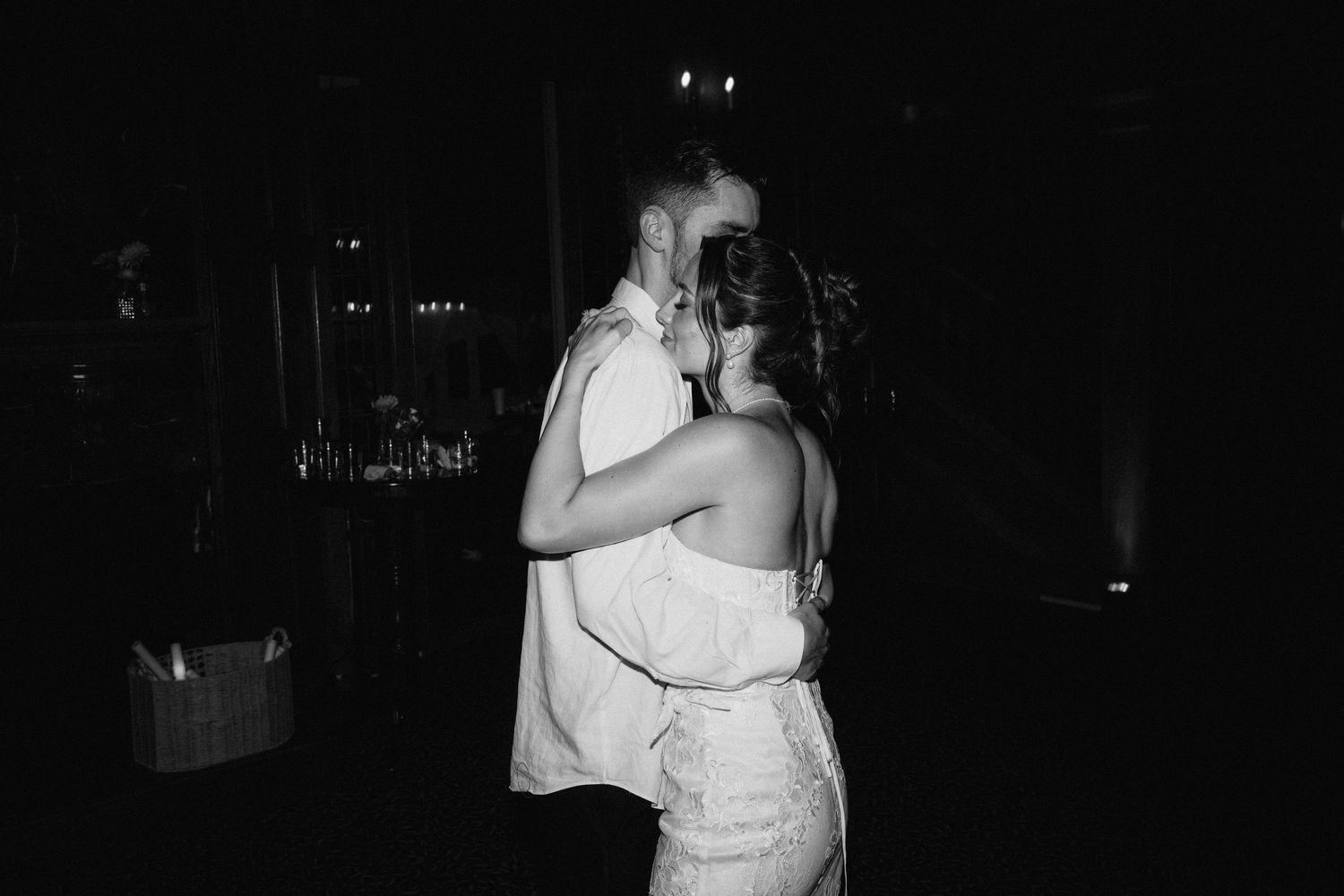 Intimate dance moments captured in dramatic low lighting at a wedding reception.