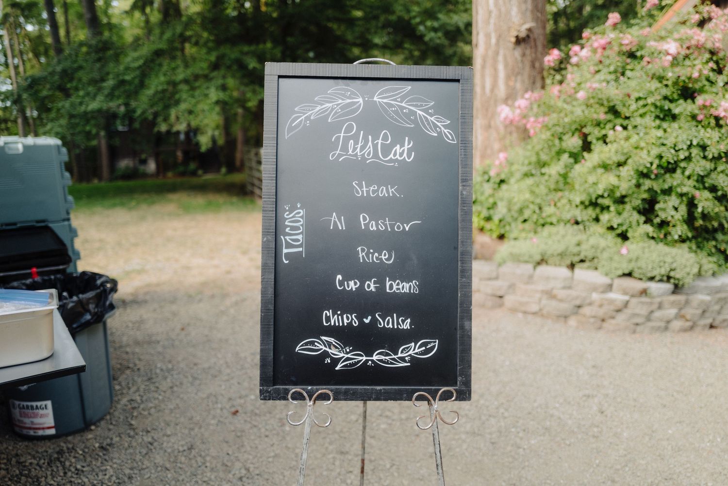 Chalkboard wedding signs with elegant script displayed at outdoor venue.