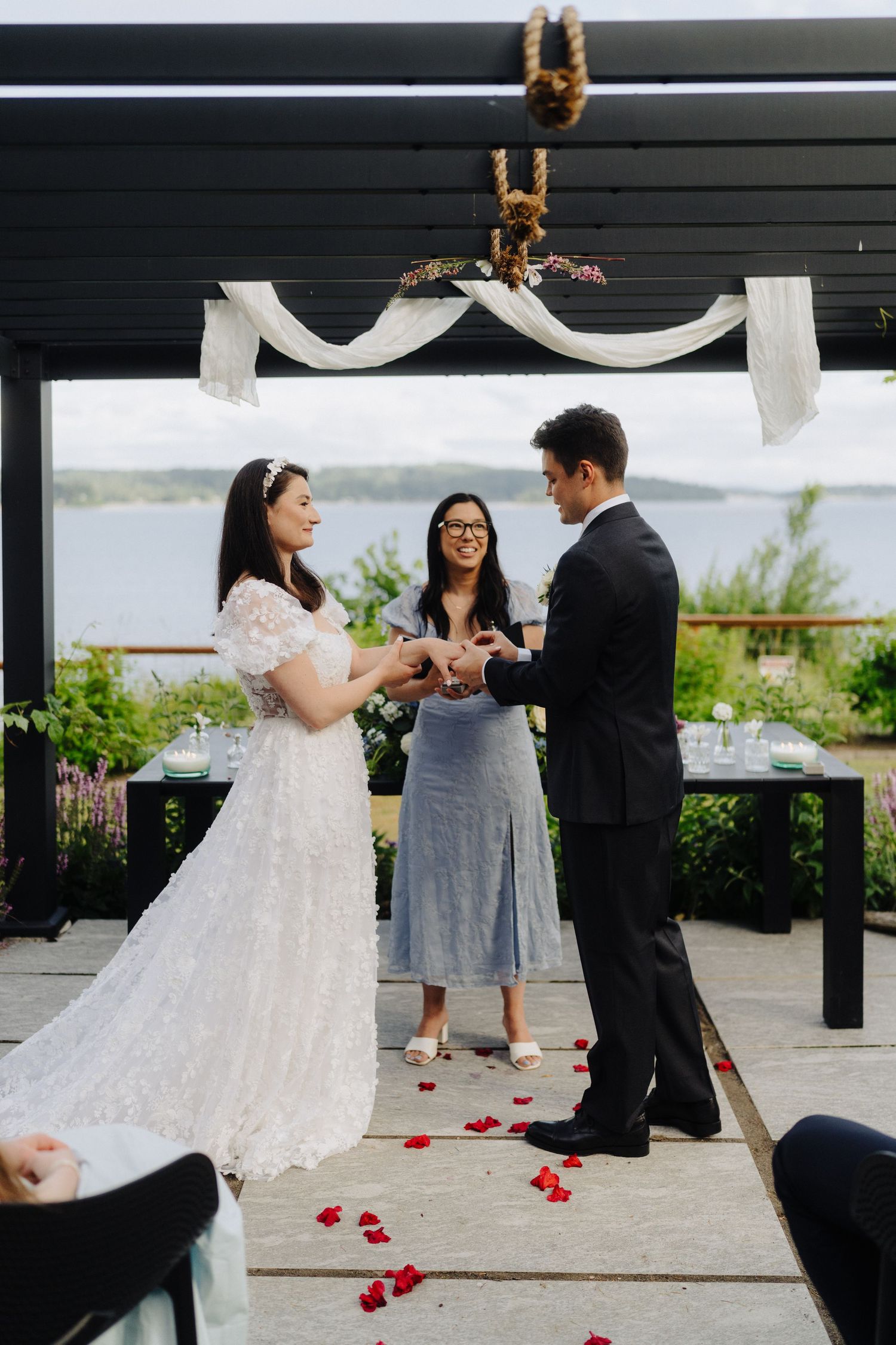 Outdoor wedding ceremony sequence showing couple exchanging vows under a modern pergola with rose petals scattered.