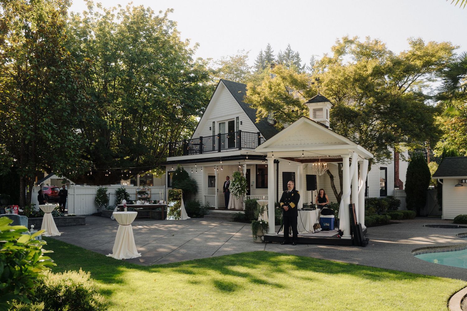Exterior view of a charming white wedding venue with classic architecture and landscaped grounds.