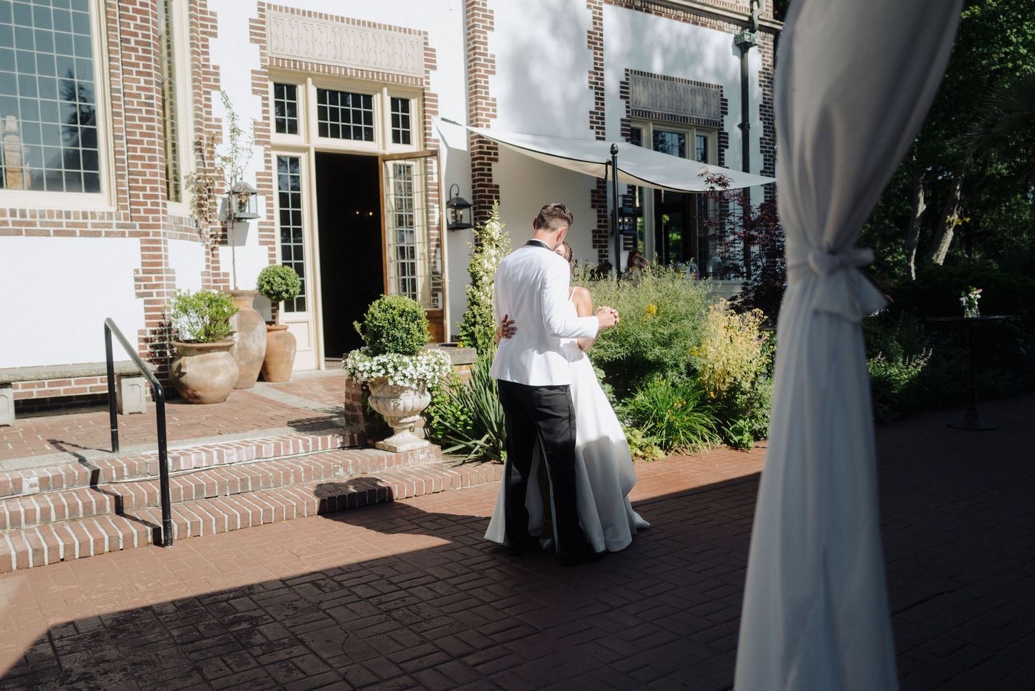 Elegant wedding venue exterior with white columns and brick detailing.