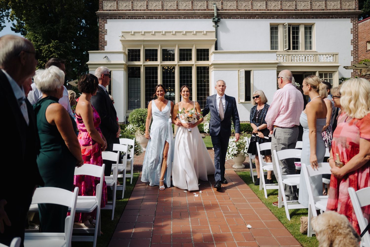 Elegant outdoor wedding venue with white chairs set up in front of a historic building.