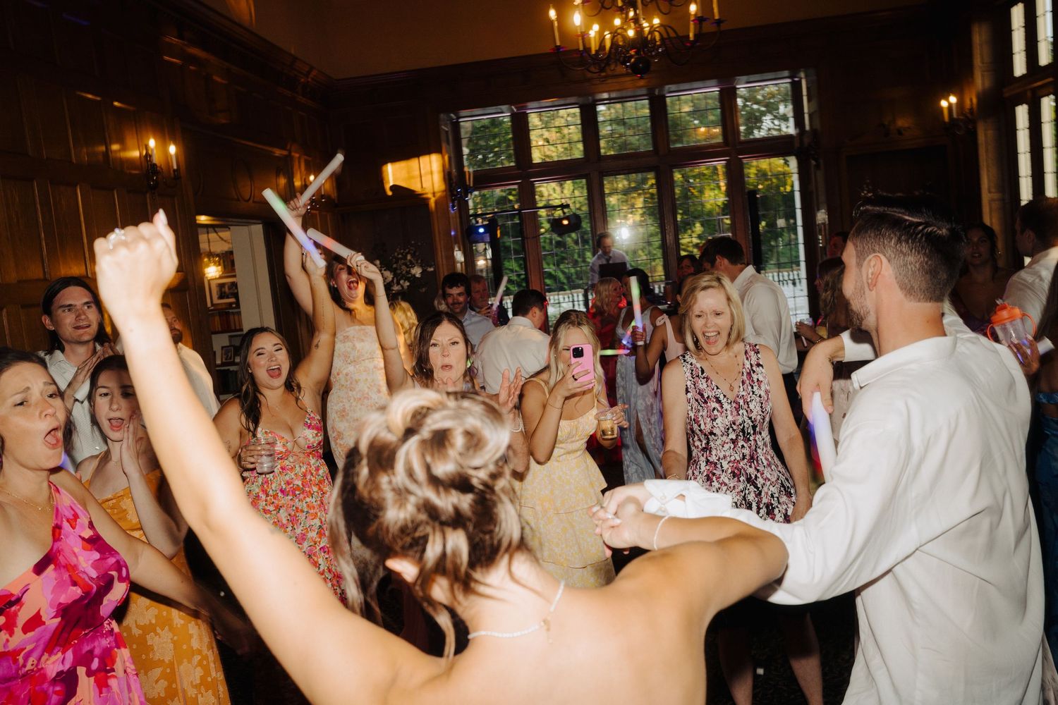 Lively dance floor scene with guests celebrating at an indoor wedding reception.