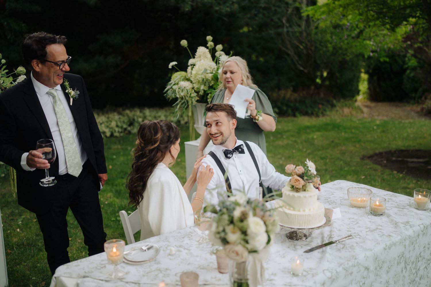Elegant wedding reception table decorated with white linens and floral centerpieces.