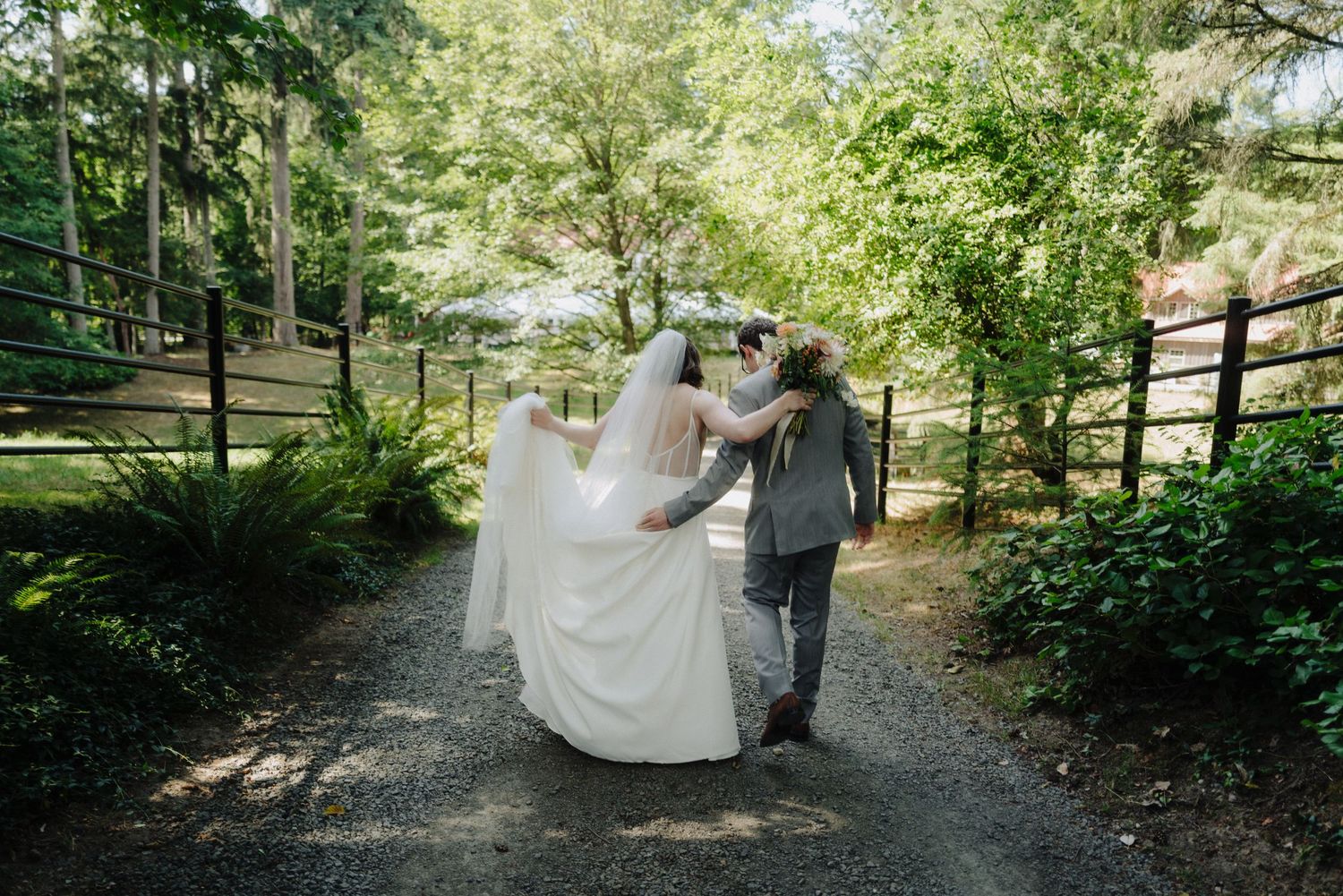 A couple walks together on a winding garden path surrounded by lush greenery.