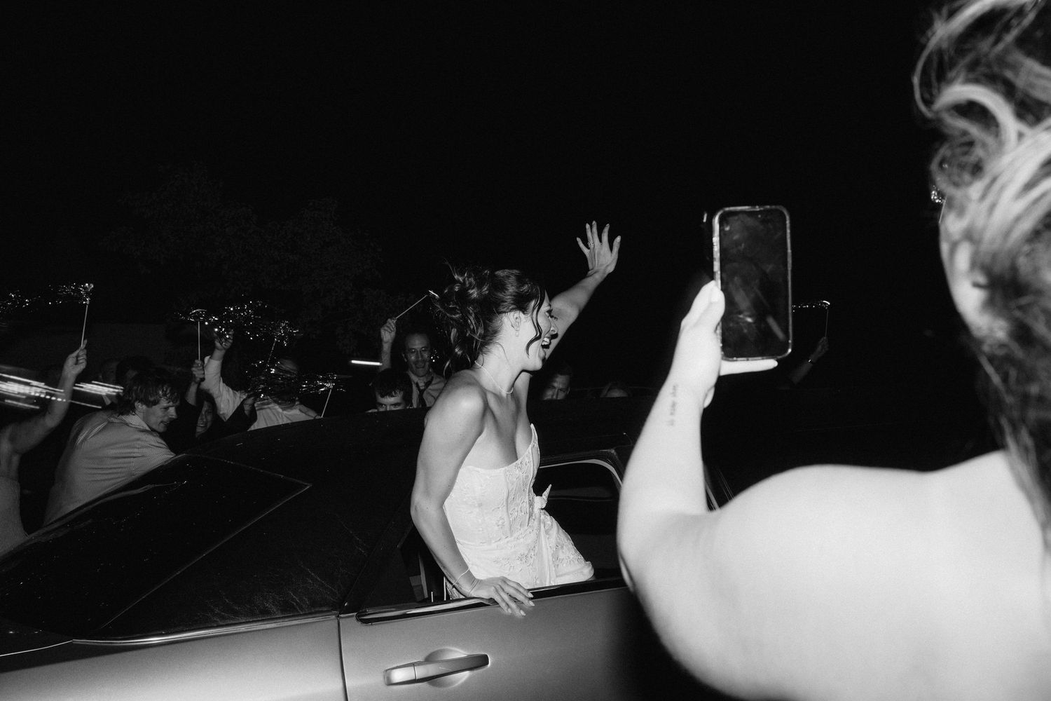 Guests dancing with raised arms during a nighttime wedding celebration.