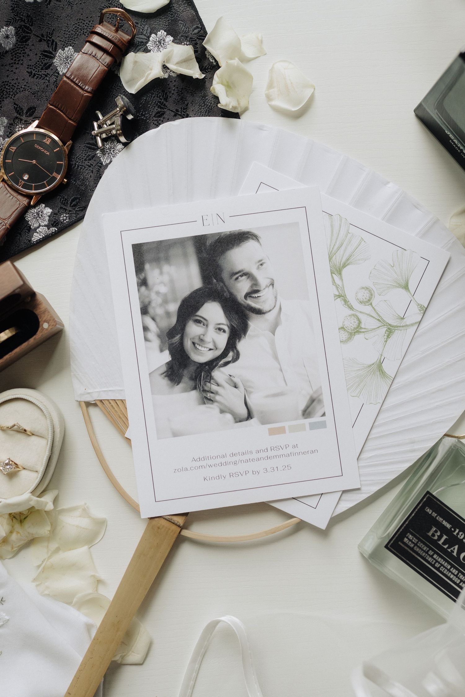 Wedding photography business cards and branding materials arranged on a white surface with floral accents.