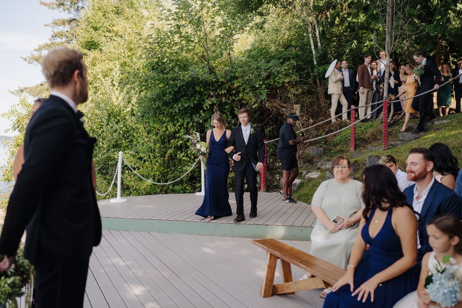 Wedding ceremony taking place on an outdoor deck overlooking a scenic waterfront view.