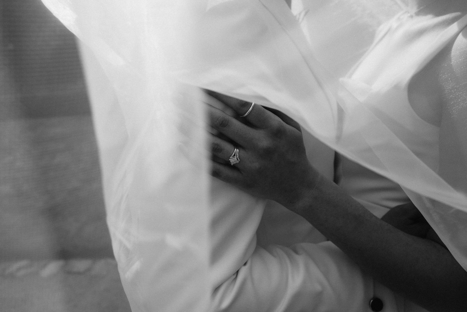 Close-up details of flowing white wedding dress fabric in motion.