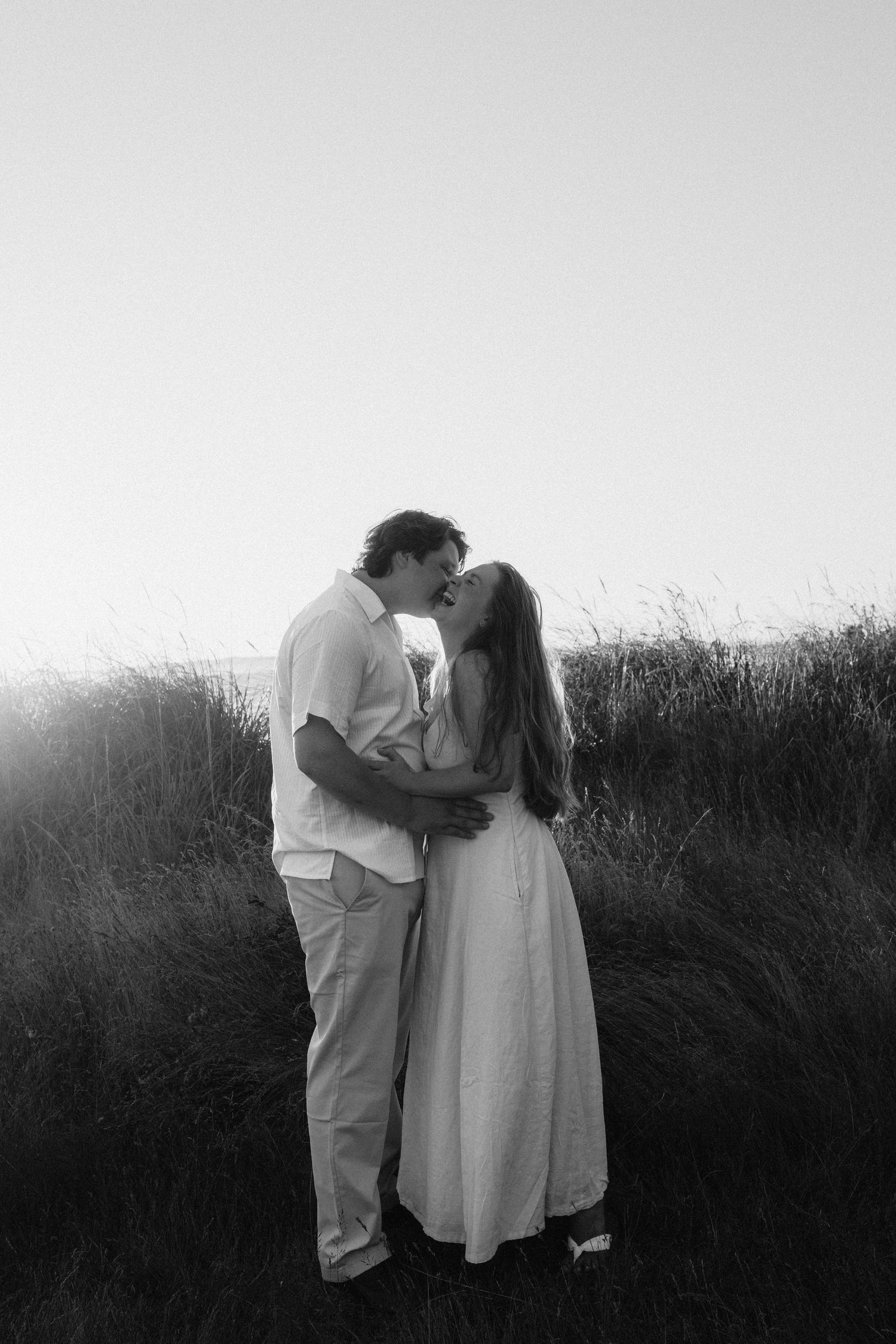 Black and white romantic portrait session in natural grassland setting.
