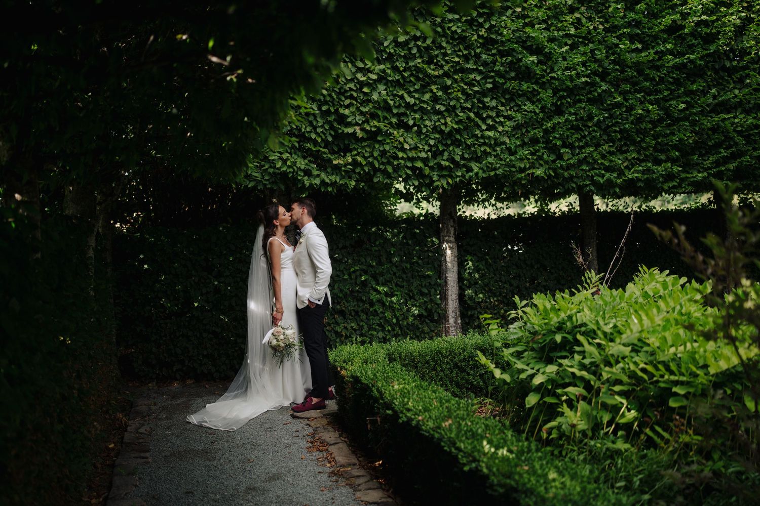 Garden wedding venue with lush green hedges and romantic pathways.