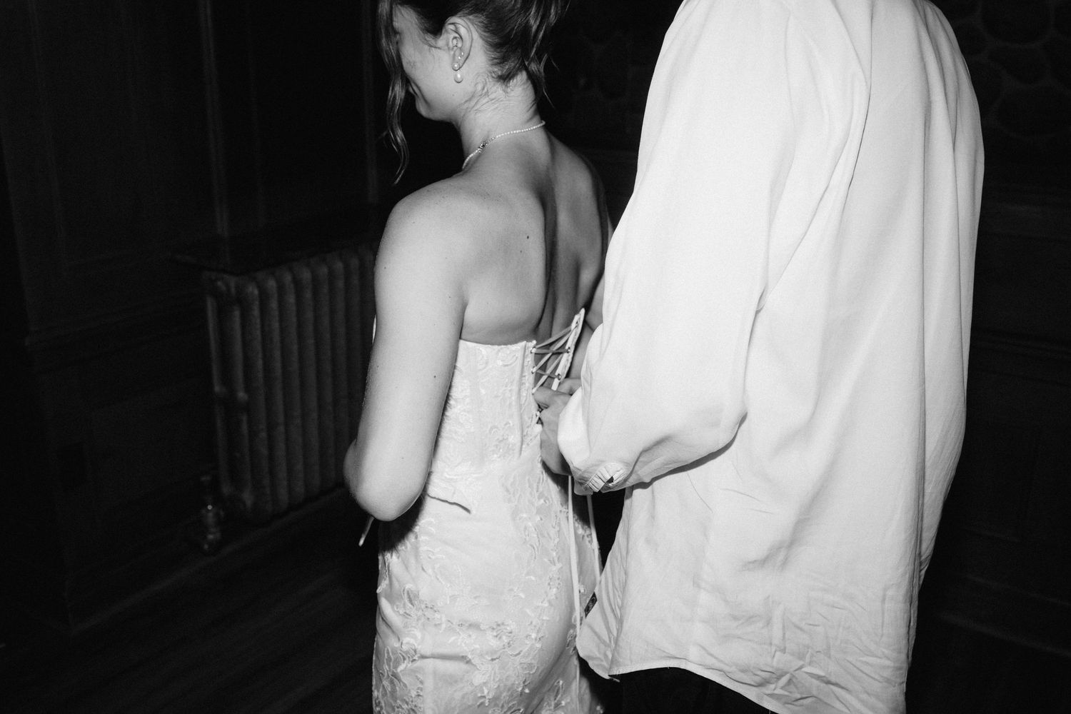 Black and white photo of wedding guests dancing and celebrating at reception.