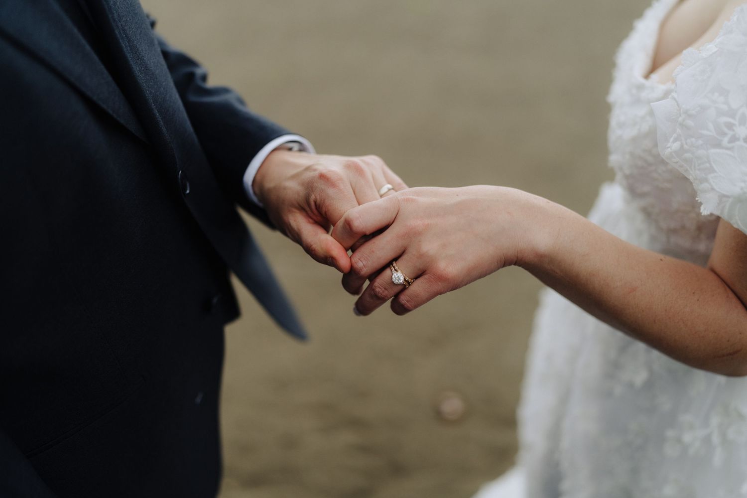 Close-up details of hands exchanging rings during a wedding ceremony.