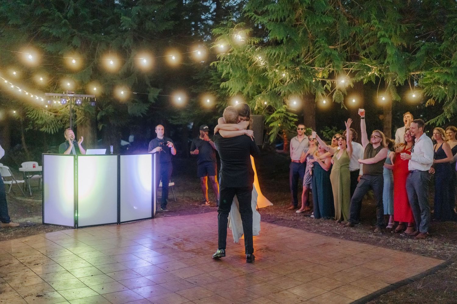 Evening wedding reception with string lights creating a romantic outdoor atmosphere.