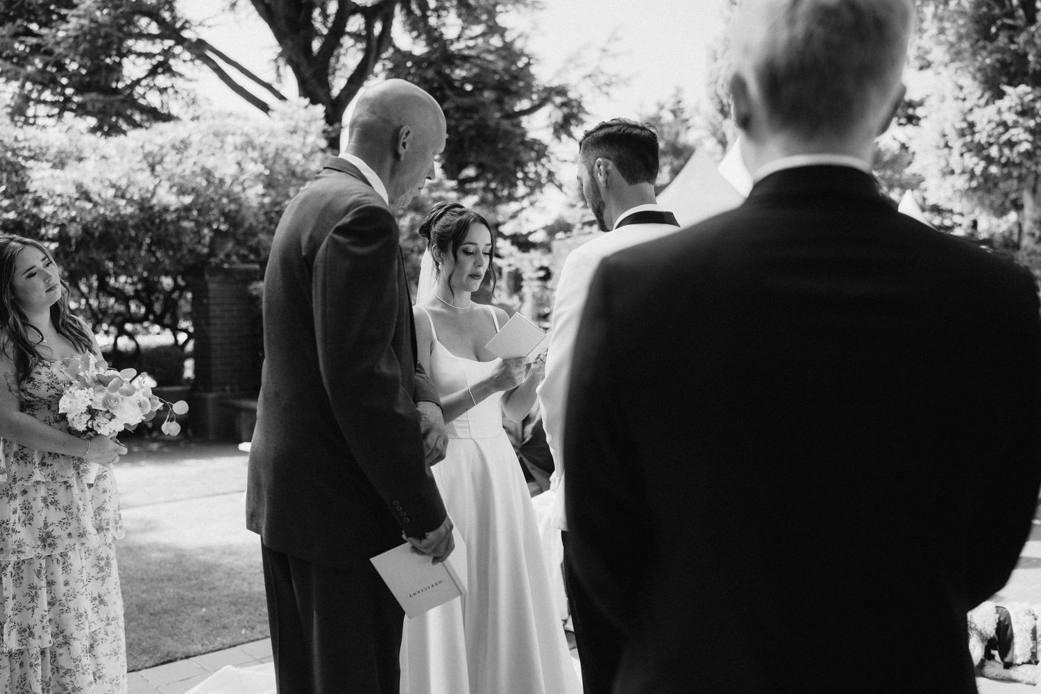 A black and white collage of wedding ceremony moments showing couples and guests in an outdoor garden setting.