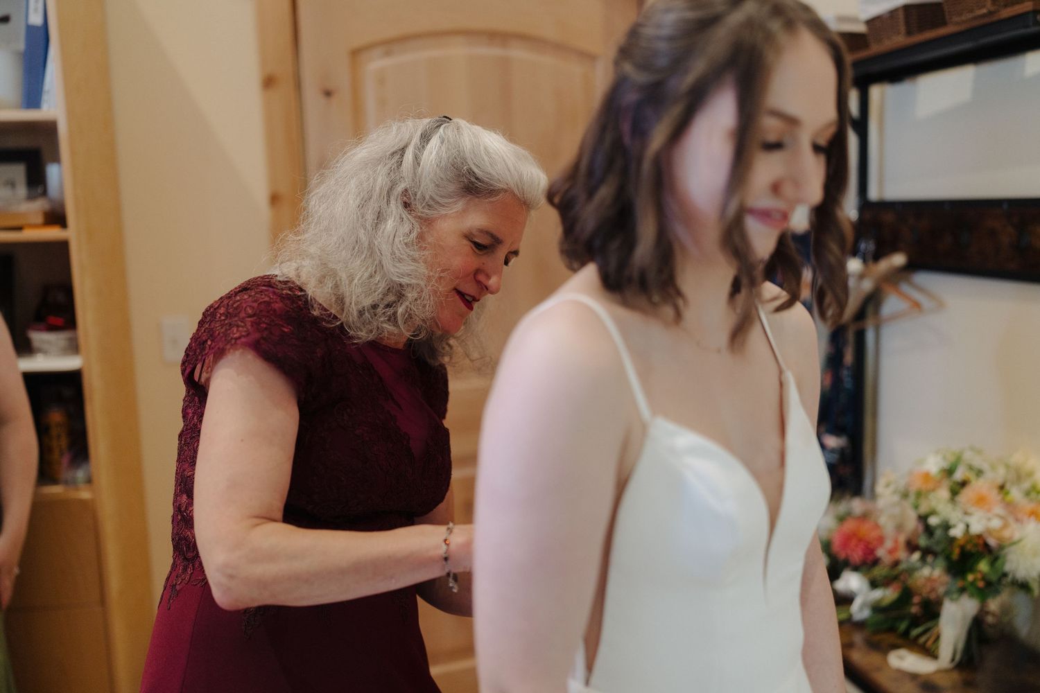 Wedding party gathered around a table signing documents during an intimate indoor ceremony.
