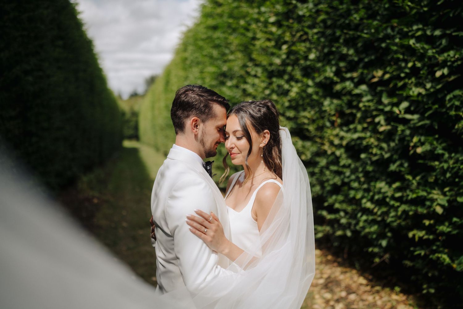 Romantic wedding moment captured in a beautiful garden setting.