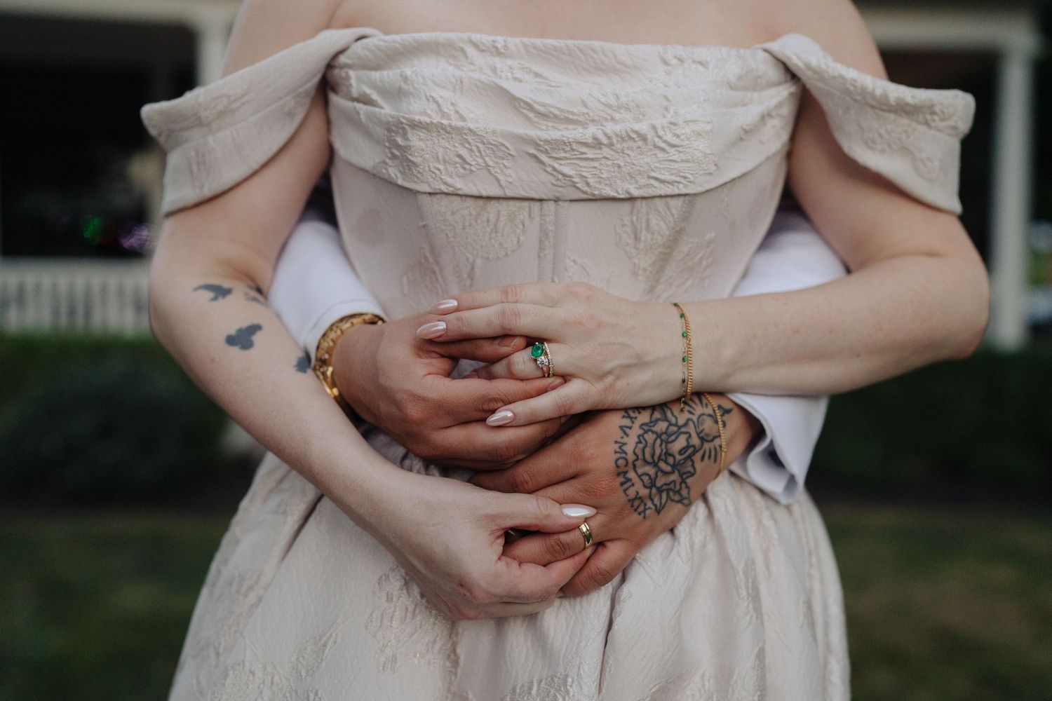 Close-up detail shot of hands with henna designs against a white dress fabric.