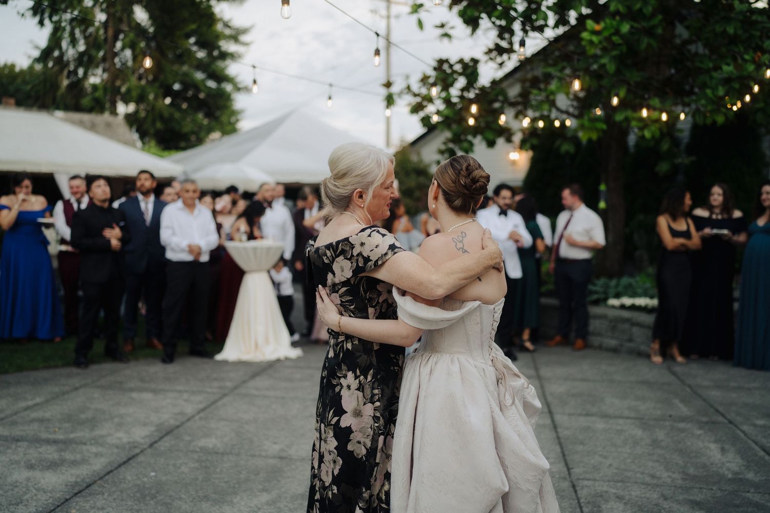 Outdoor wedding reception venue with string lights and trees creating a romantic garden atmosphere.