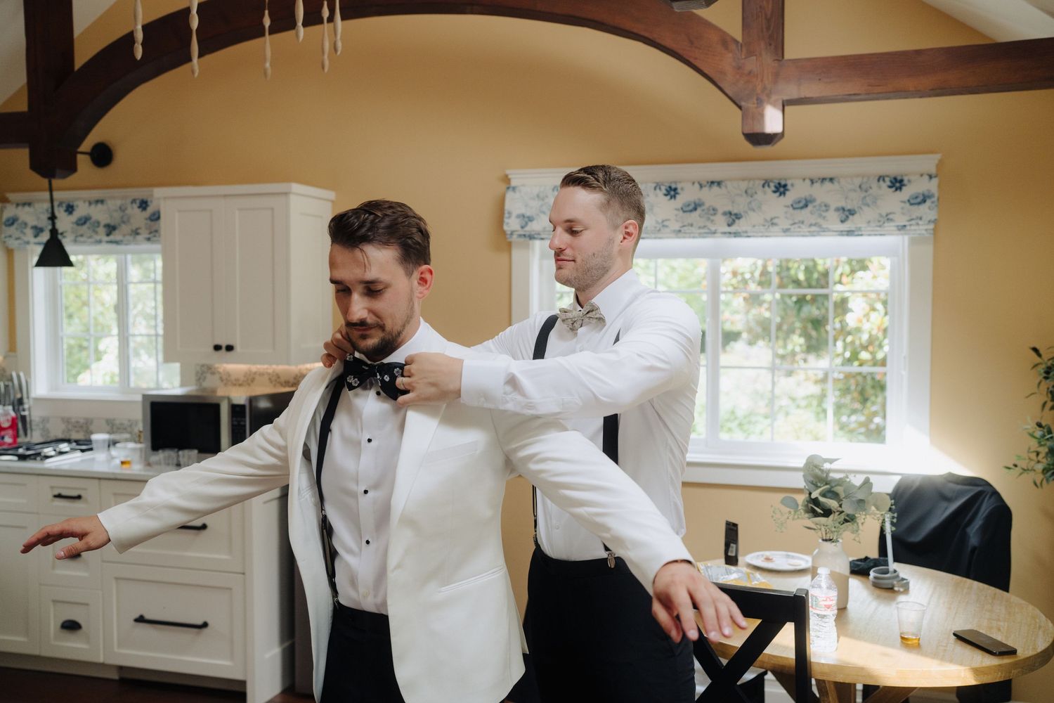 Wedding party members dancing and celebrating together in a bright indoor venue.