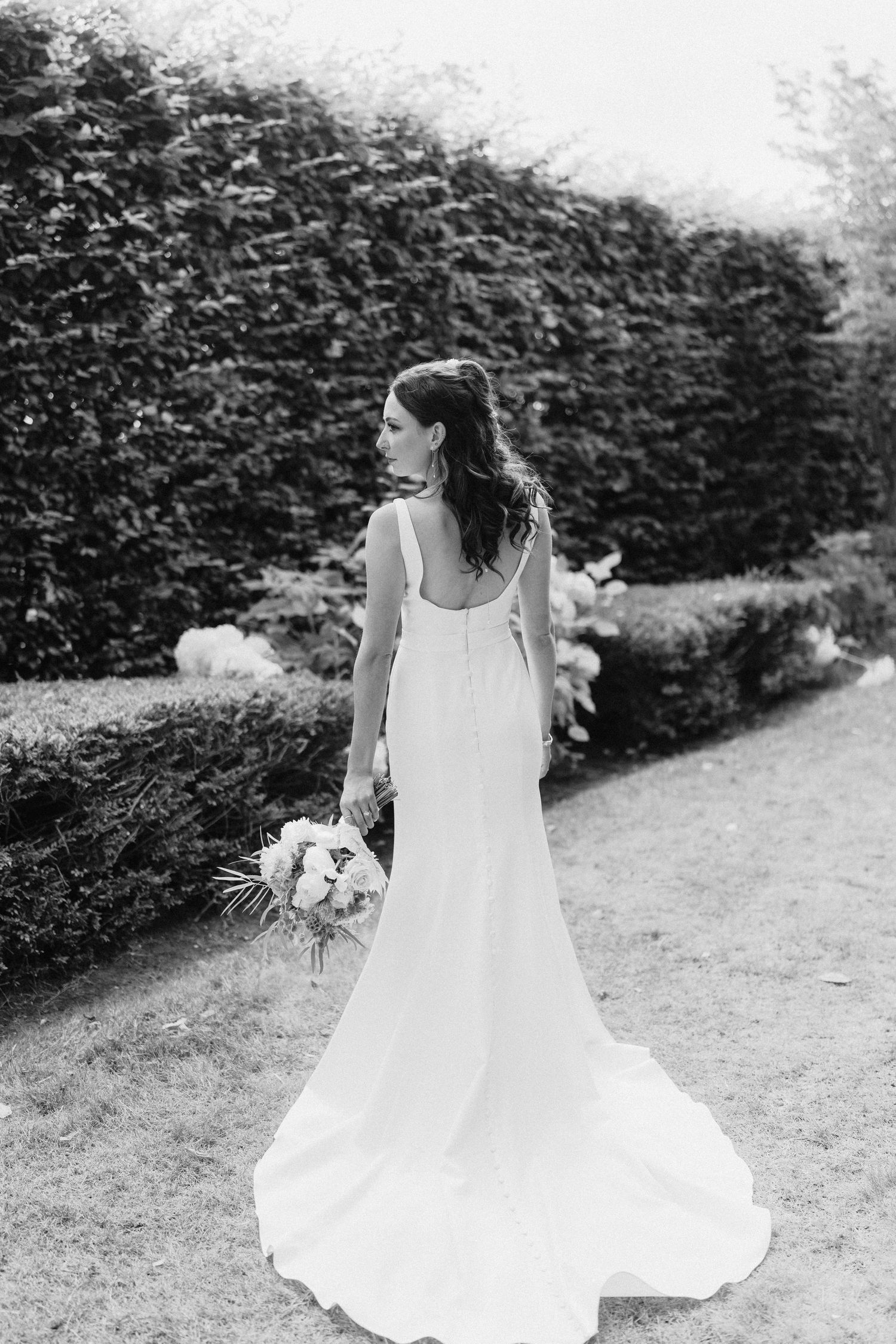 Elegant bride spins her white wedding dress in a series of artistic black and white garden photographs.