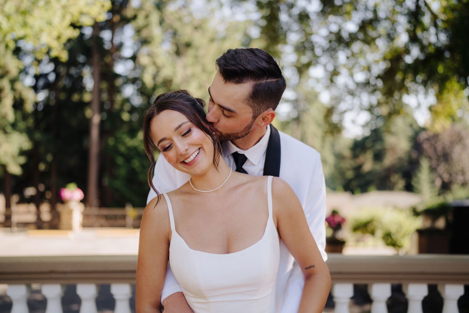 Wedding party shares candid moments and laughter during outdoor summer celebration.