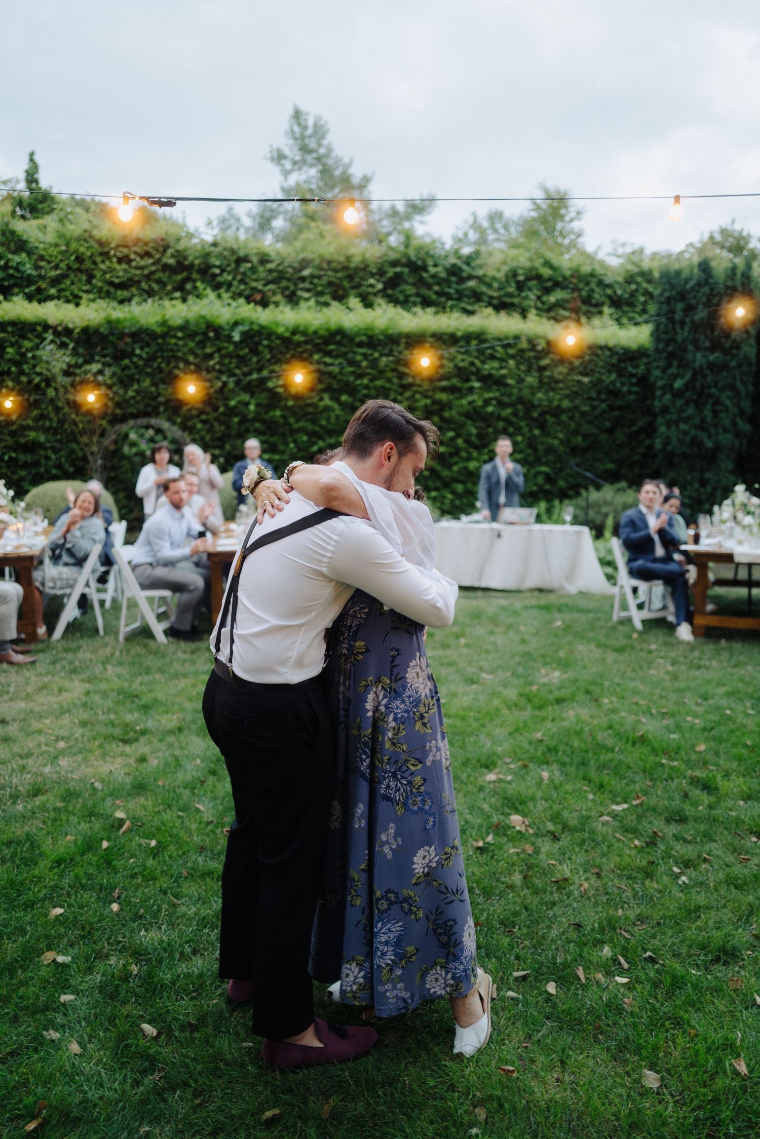 Couples sharing intimate dances on lawn during outdoor evening celebration.