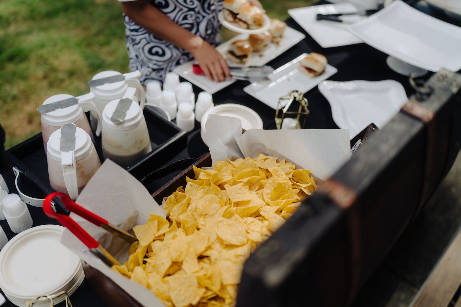 Buffet table at wedding reception featuring chips and casual dining options.