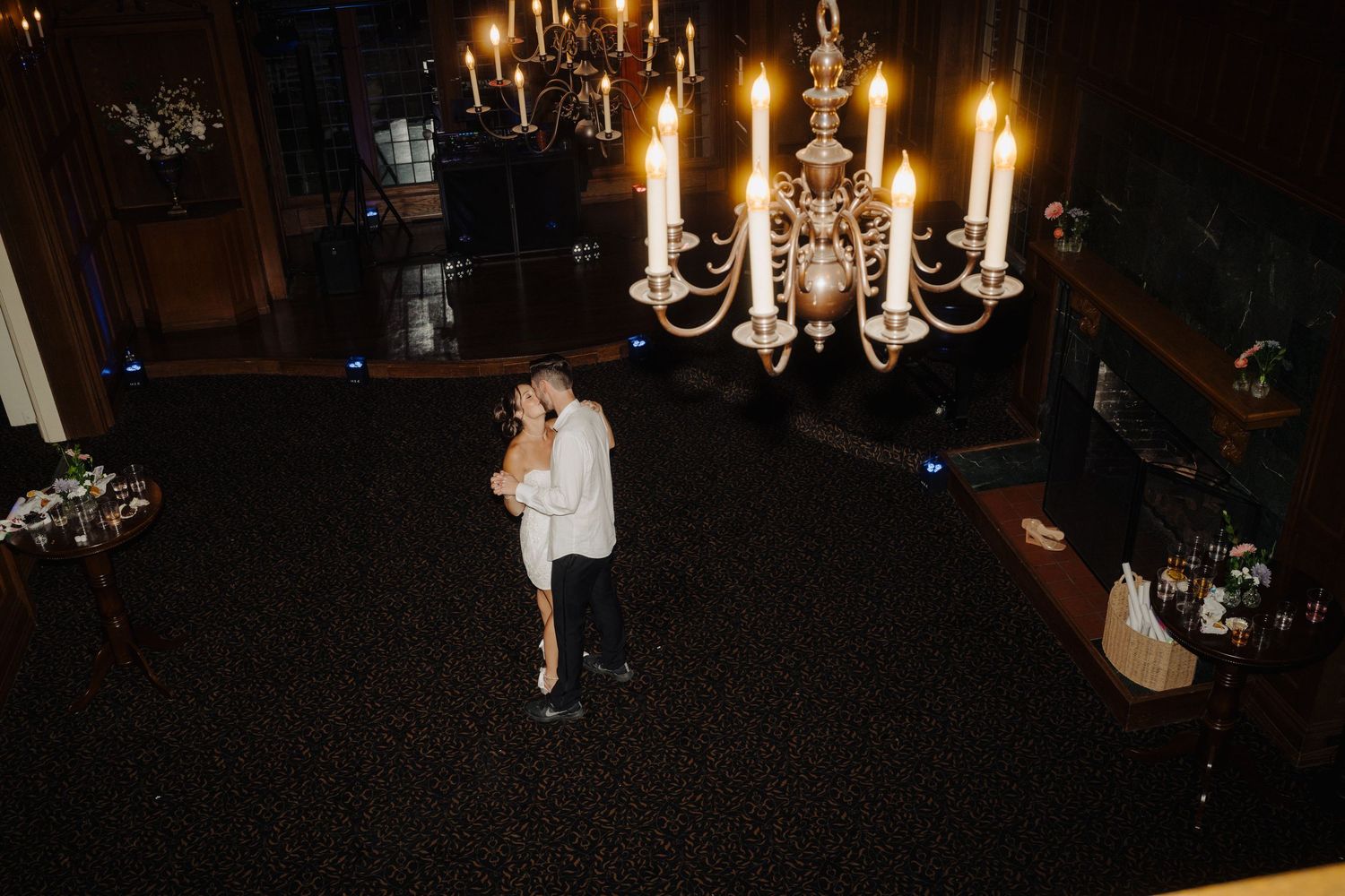 Romantic candlelit reception venue with crystal chandeliers creating ambient lighting.