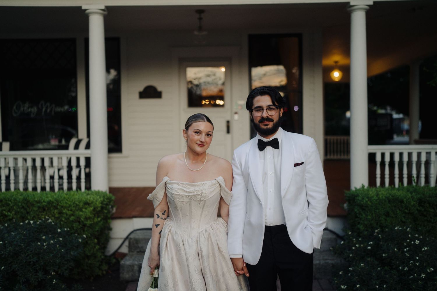 Classic white colonial style house with columns and porch as wedding venue.
