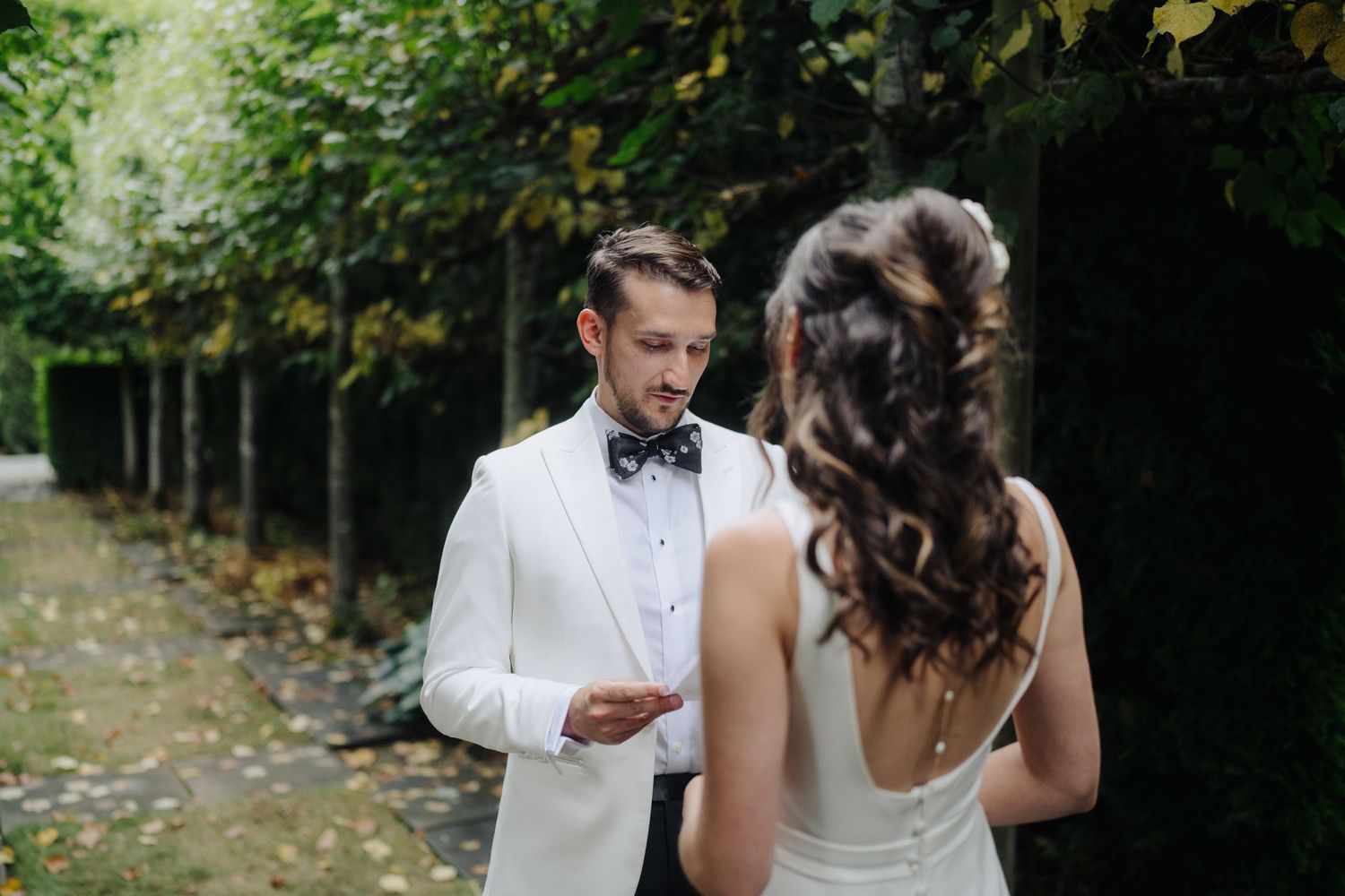 First look moment between couple on a scenic outdoor path surrounded by lush greenery.