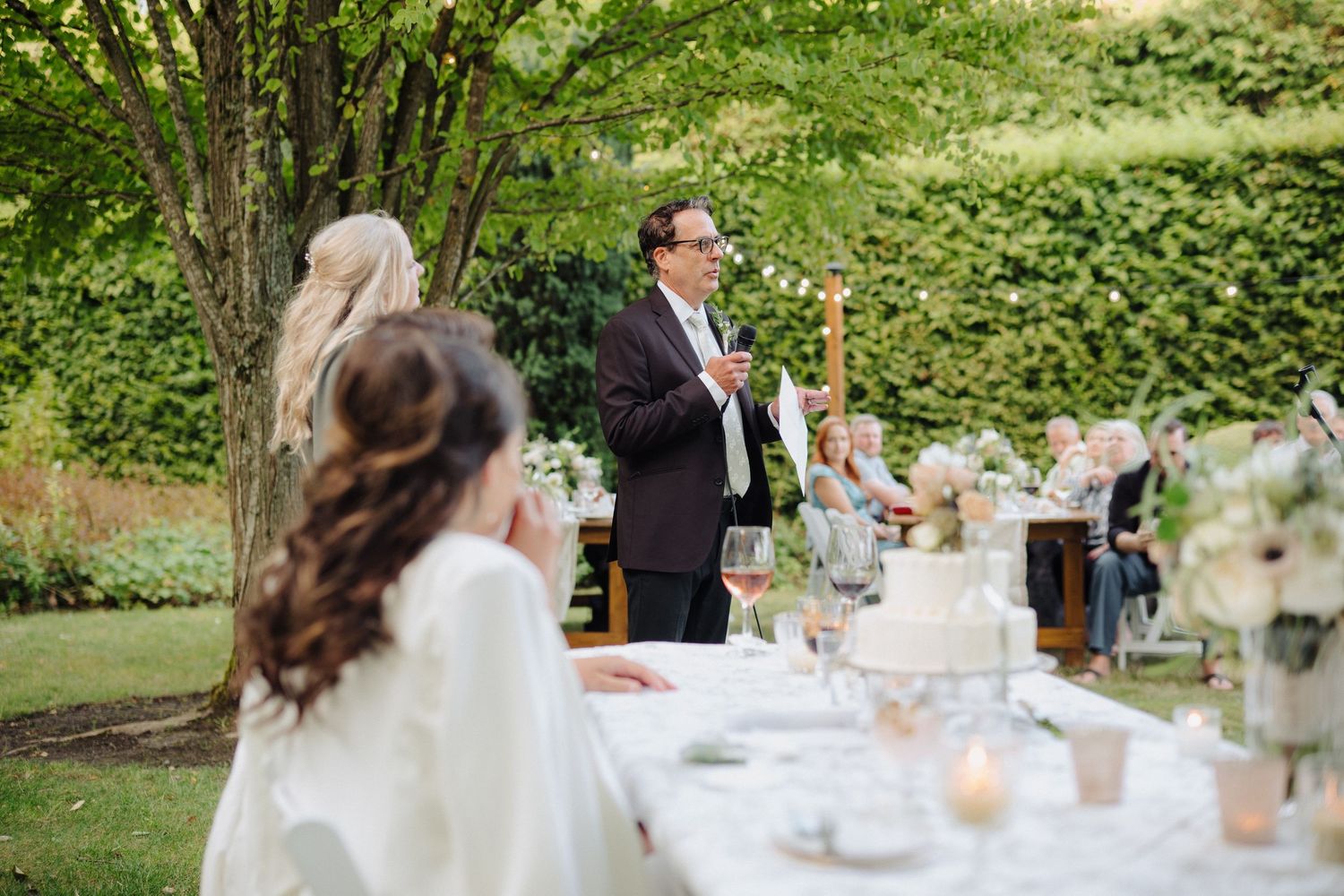 Garden wedding reception with decorated tables and natural greenery creating an intimate outdoor atmosphere.