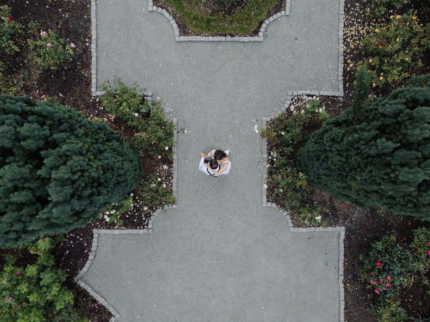 Aerial view of a concrete courtyard surrounded by manicured hedges and gardens.
