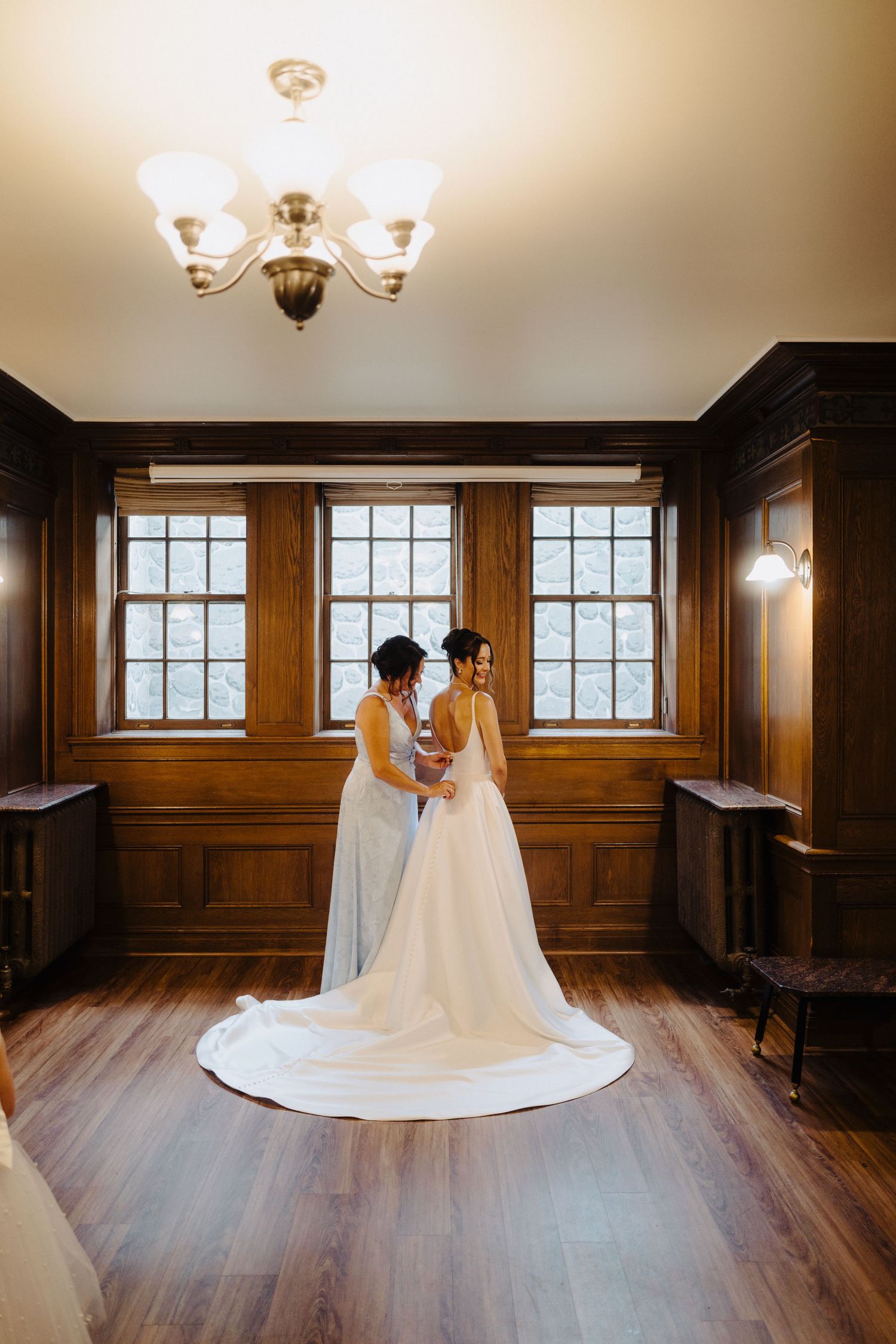 Elegant wedding photos in a wood-paneled room with natural light streaming through windows.