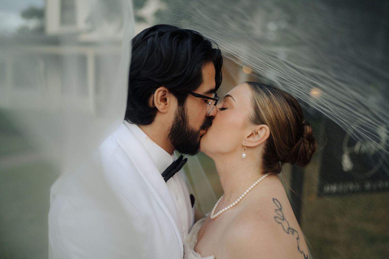 Romantic moment captured between newlyweds in a moody, artistic outdoor portrait.