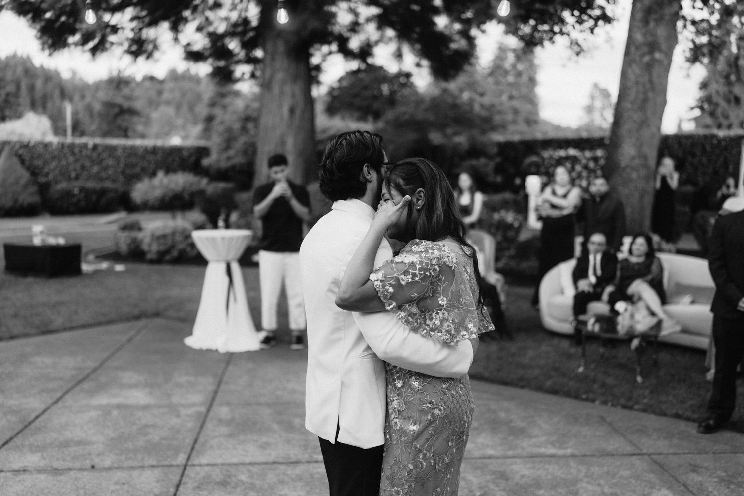 Black and white photo of a couple dancing at an outdoor wedding reception.