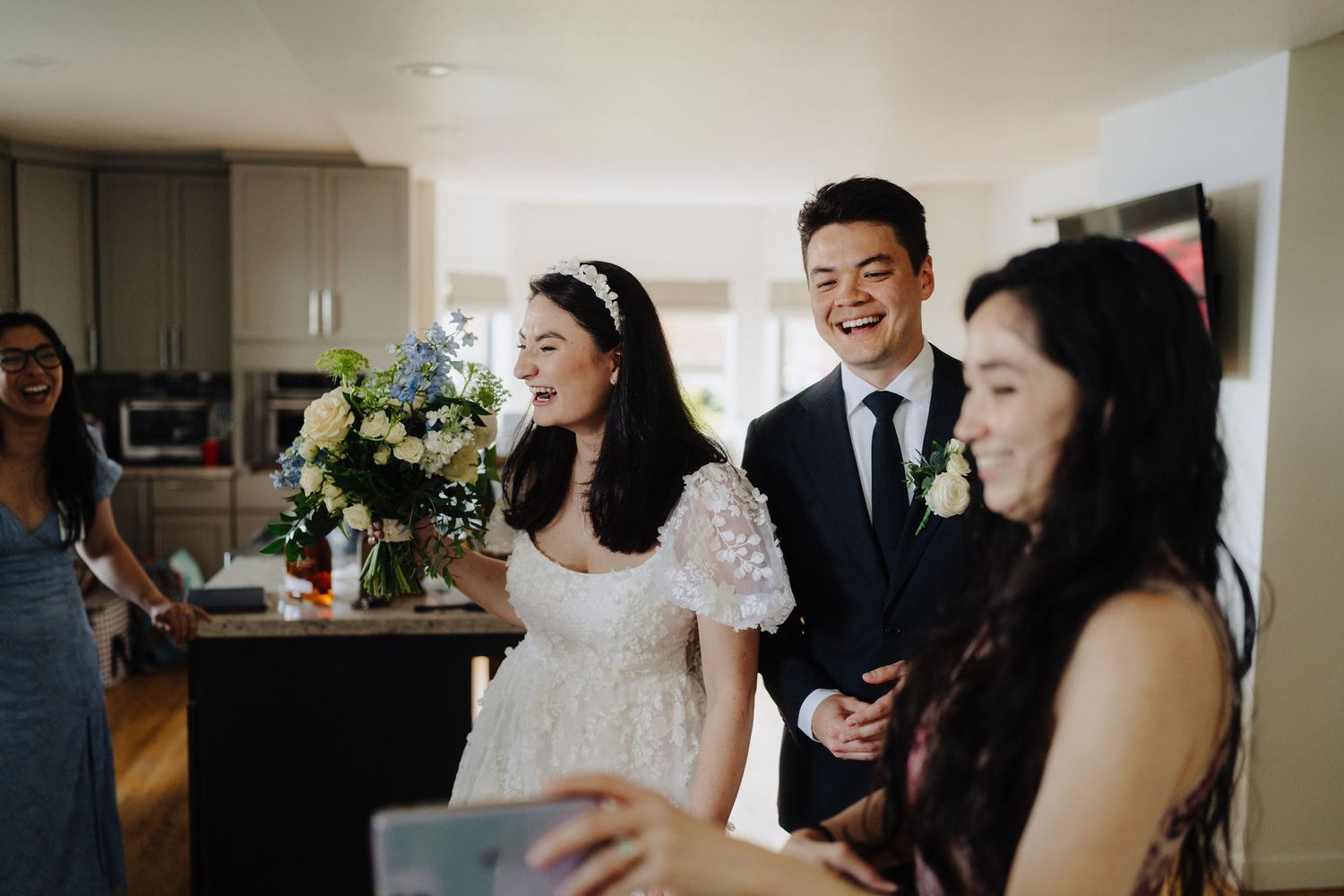 Wedding guests gather in a bright indoor space during pre-ceremony preparations.