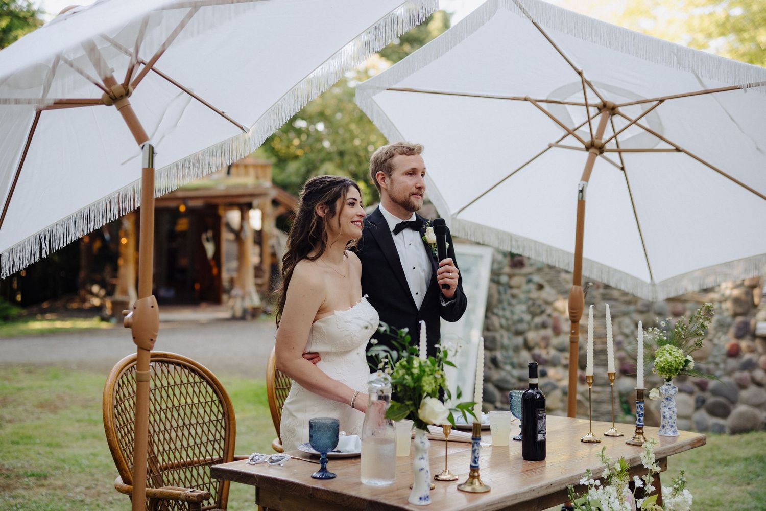 White umbrellas and elegant table settings create an intimate outdoor dining atmosphere.