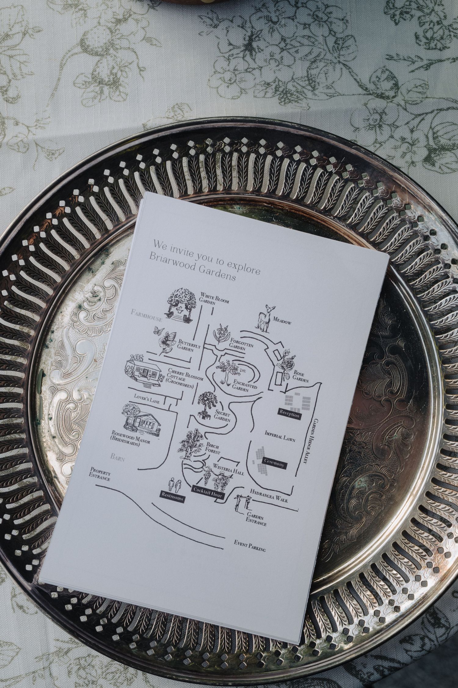 Wedding seating chart diagrams displayed on decorative silver platters.